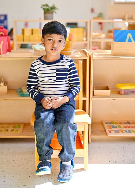 Child standing confidently in Montessori classroom