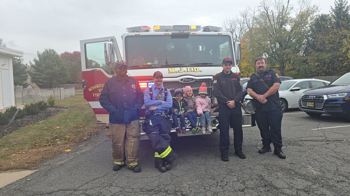 Children in colorful hats during the fire truck community visit