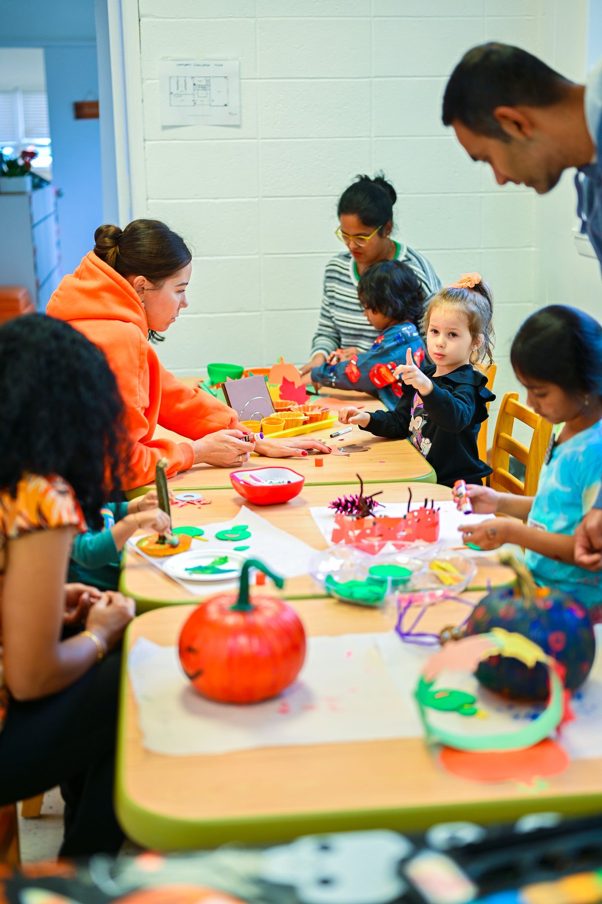 Child in Halloween costume holding a pumpkin at Milestones event