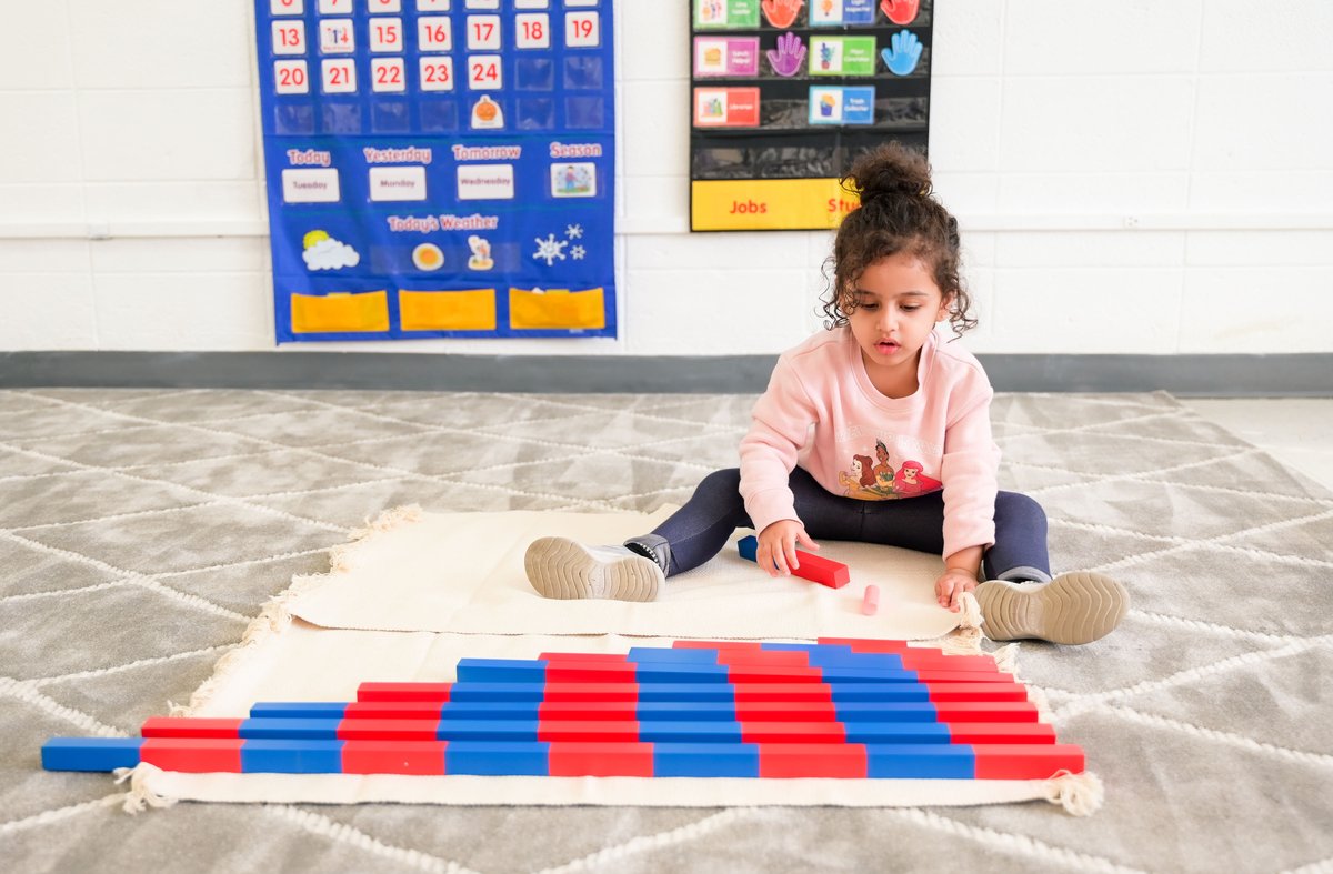Child engaged in focused Montessori work period activity