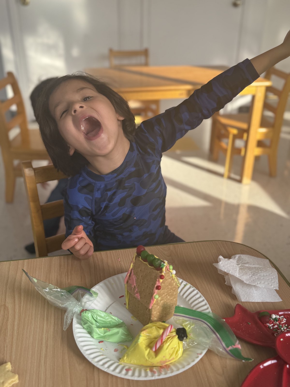 Child proudly showing their handmade holiday ornament