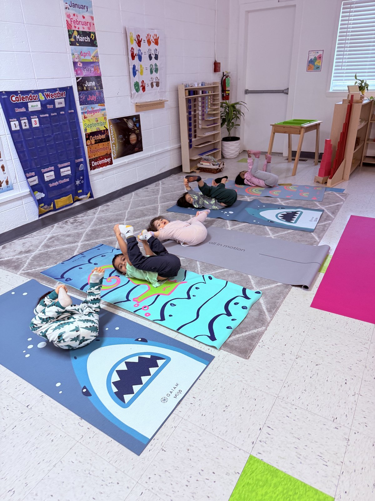 Children engaged in imaginative floor play in the classroom