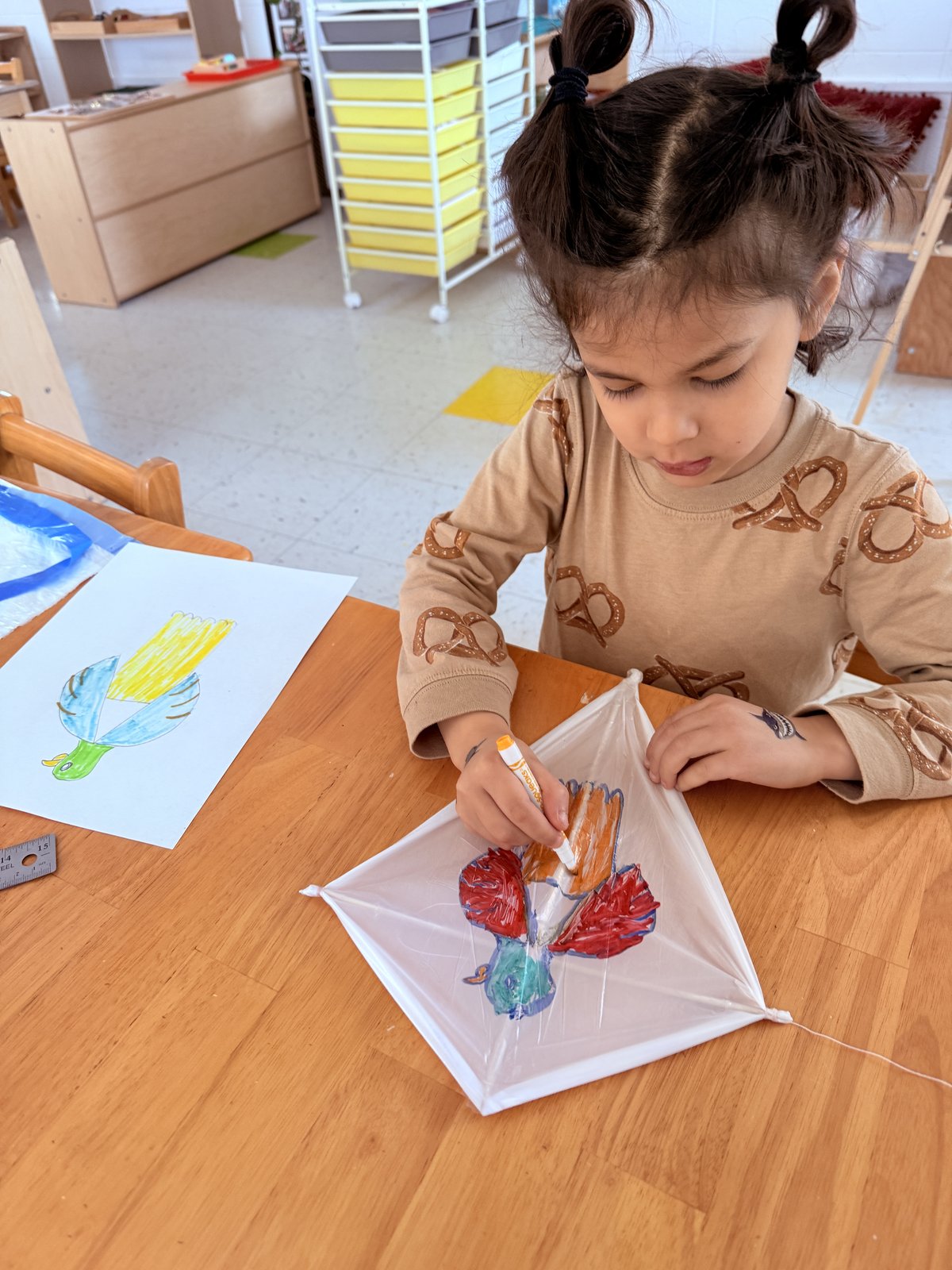 Student painting and decorating a handmade kite