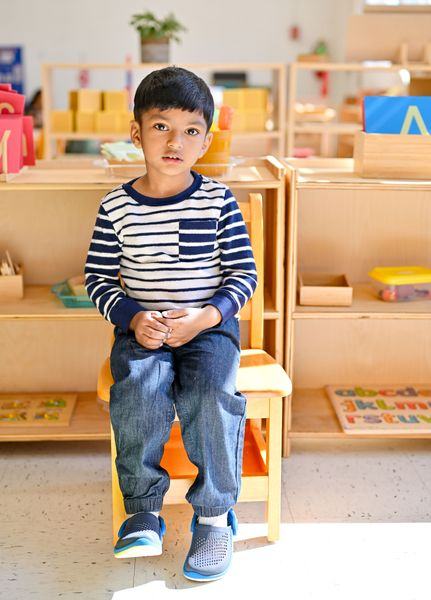 Child standing confidently in Montessori classroom