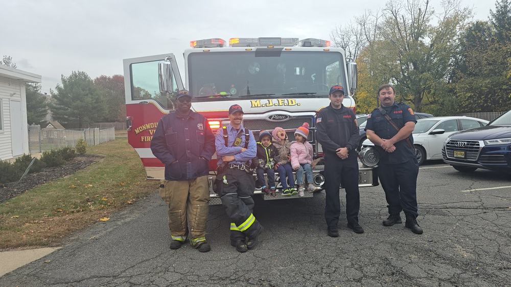 Milestones students posing with firefighters in front of fire truck