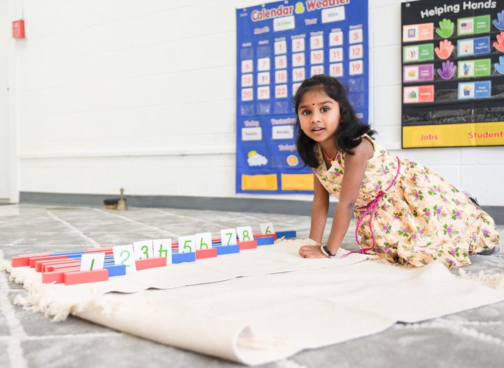 Child carefully arranging Montessori learning materials