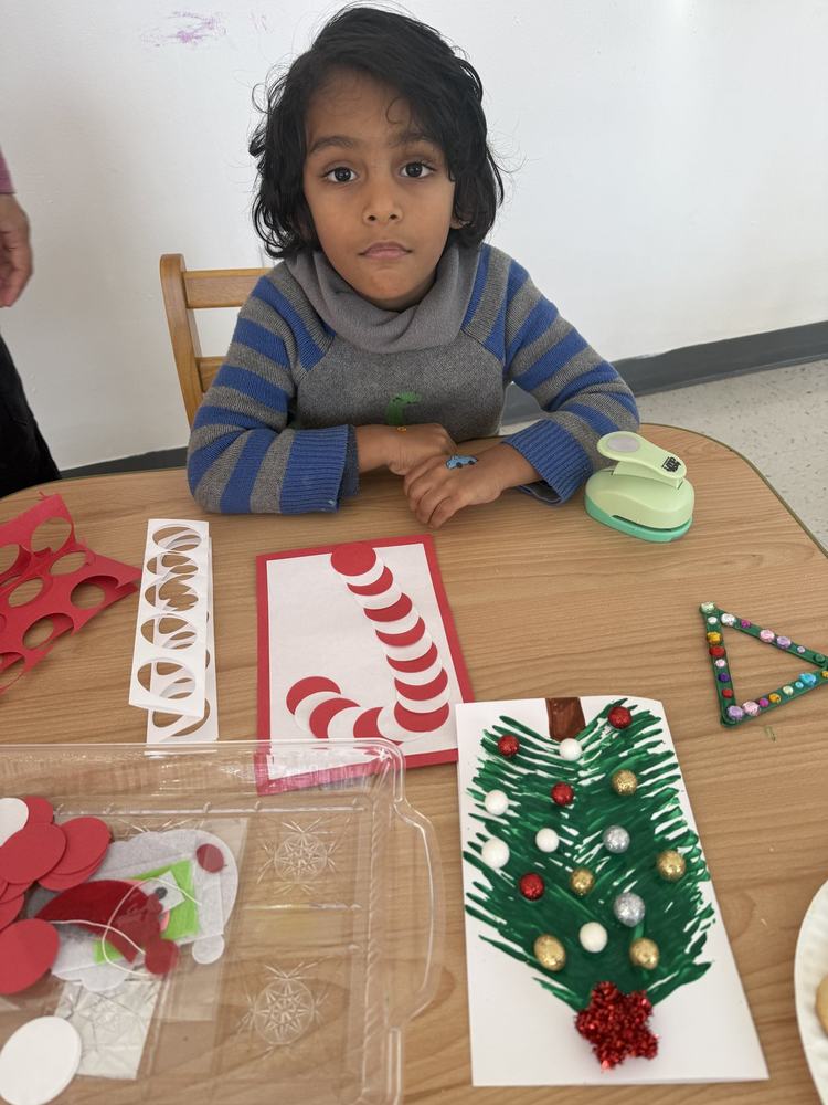 Child surrounded by Christmas craft projects and decorations