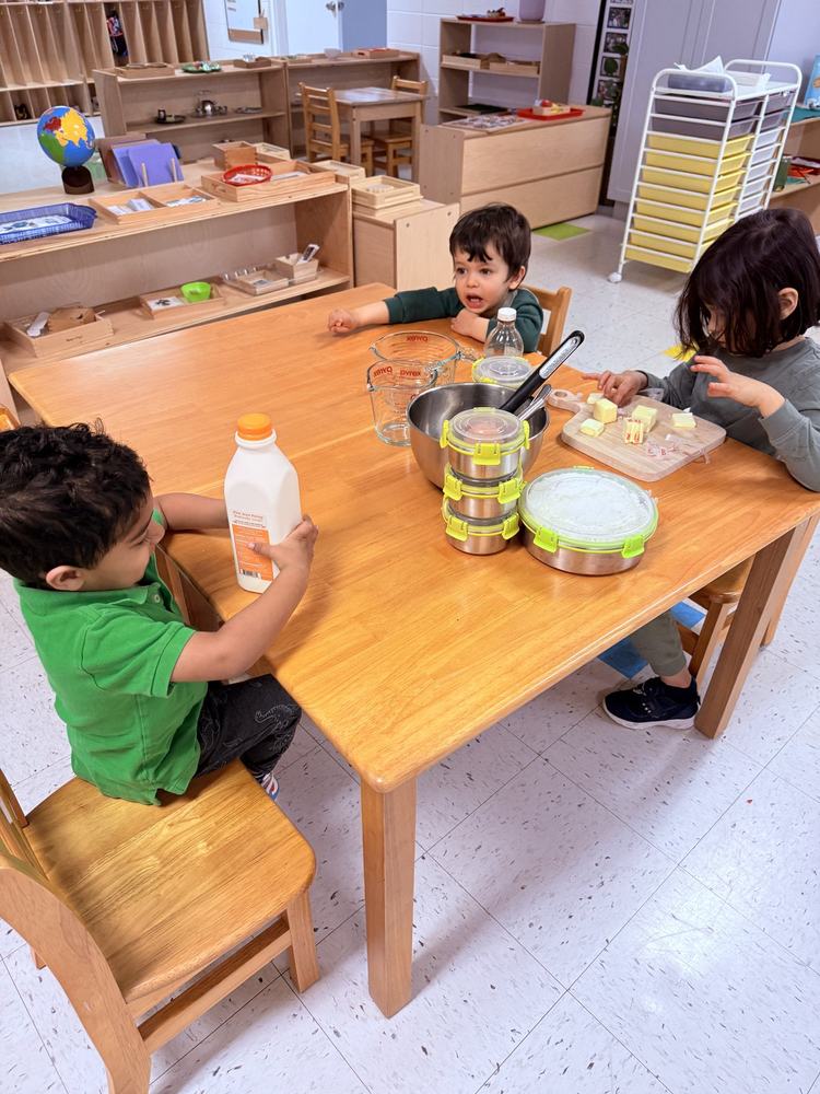 Two children smiling during collaborative Montessori work
